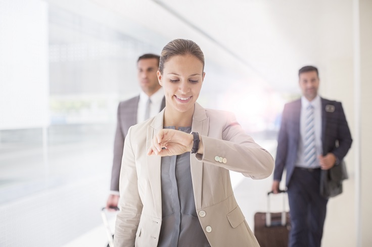 image is showing businesswoman checking wristwatch in corridor of in San Diego Internarional Airport