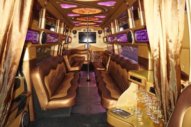 golden party bus interior with pole and tv