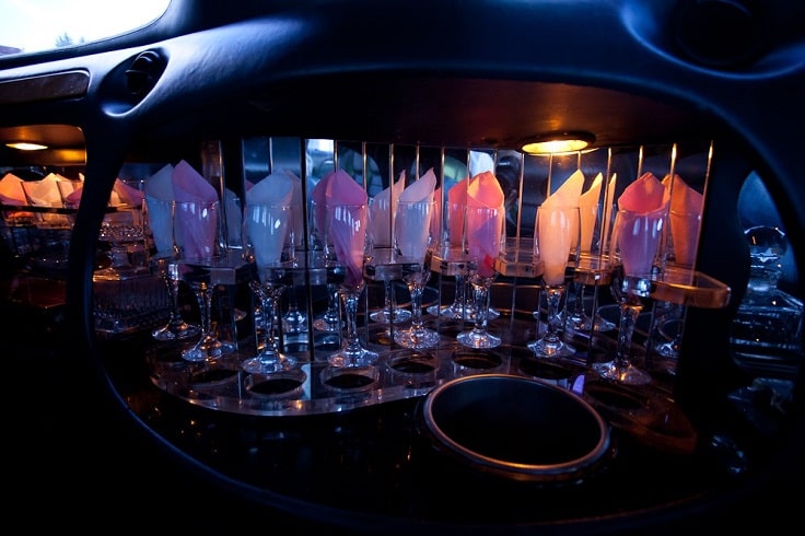 wine glasses with pink, yellow, and white napkins inside of party bus bar